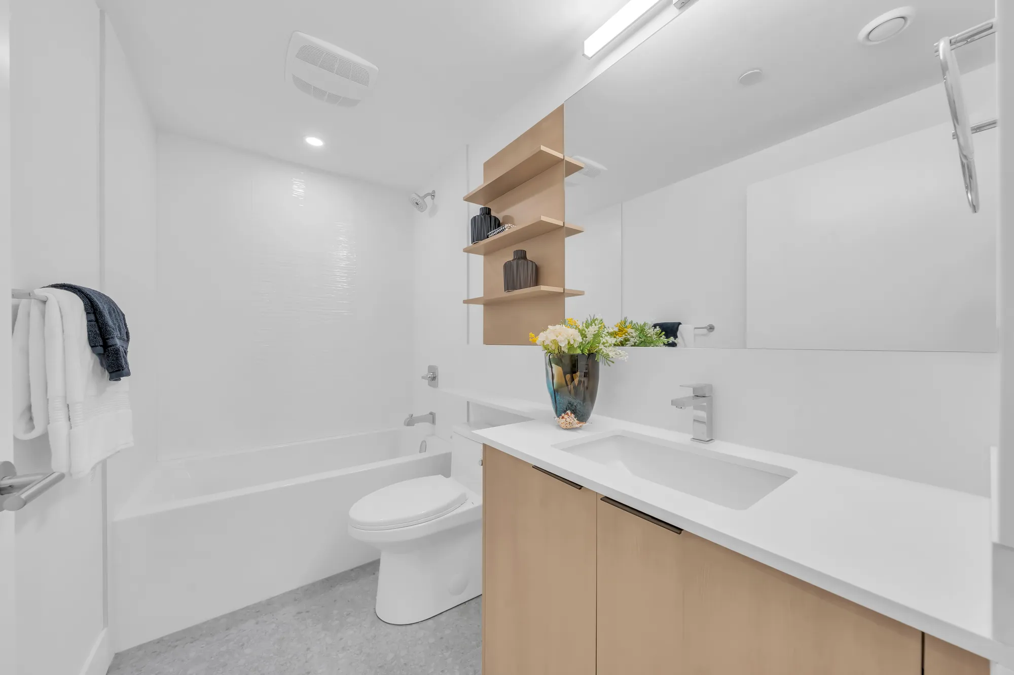 The second bathroom: a tub with a shower, white tile, an oak vanity, a toilet
