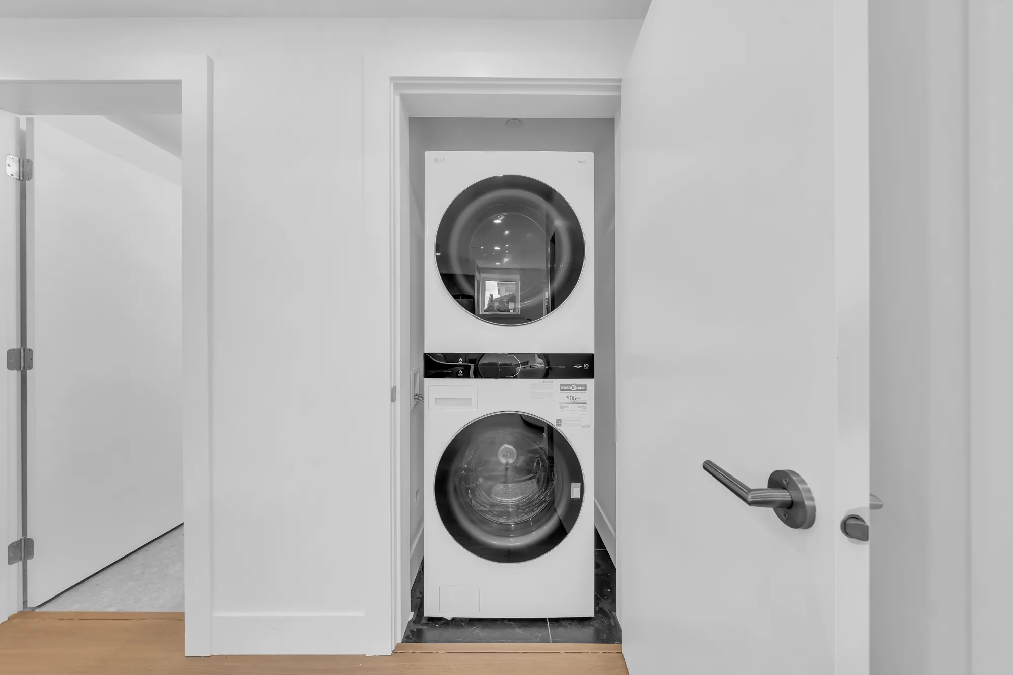 A stacked washer and dryer in a closet off the hall